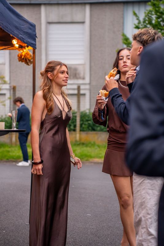 Bal promo 2029, scène de cocktail en extérieur, ambiance de fin de journée