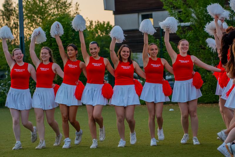 Pom-pom girls ENSCL, ligne d'équipe pompons levés au coucher de soleil