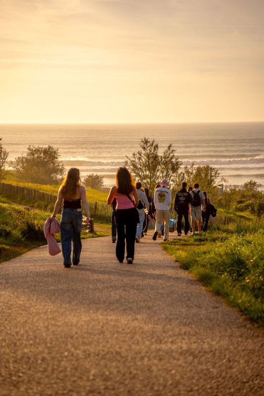 Ride It, groupe descendant vers l'océan au coucher de soleil, planches à la main